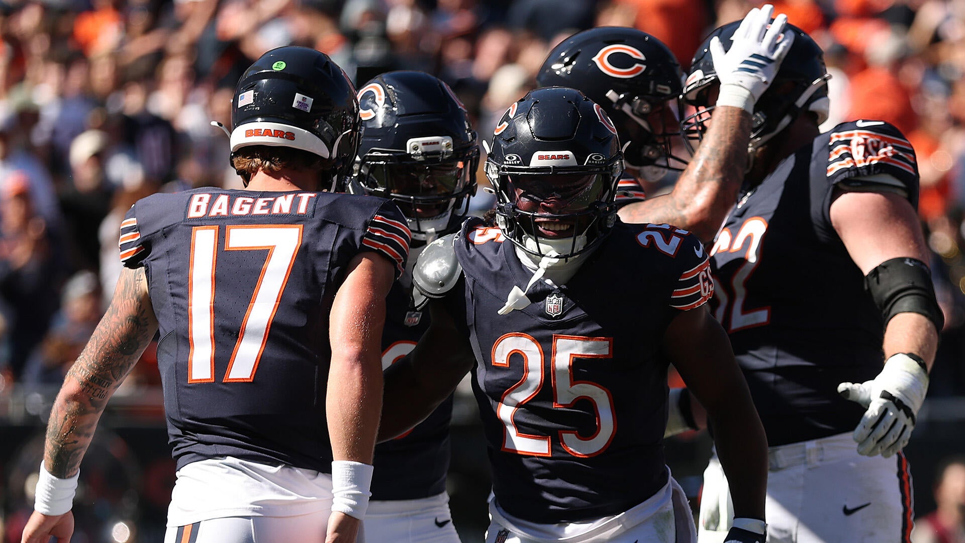 A group of five Chicago Bears players in blue jerseys celebrate a touchdown.
