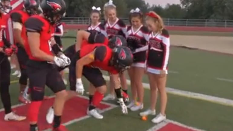 Cheerleader battling leukemia brought to tears by football team's moving gesture