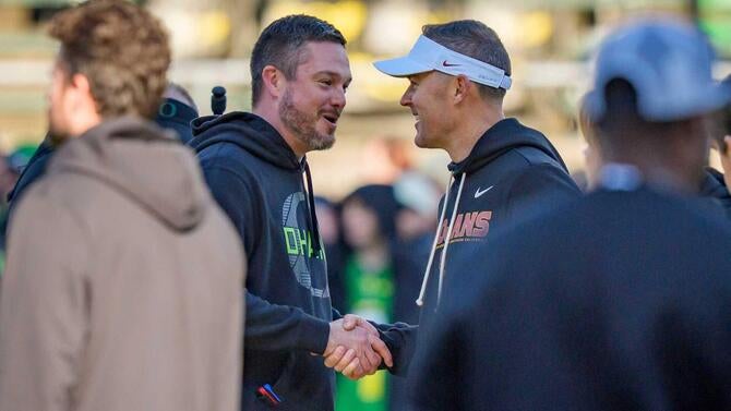 Oregon head coach Dan Lanning, left, and USC head coach Lincoln Riley shake hands before the game as the Oregon Ducks host the
