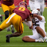 Oregon quarterback Dante Moore is hit after sliding by USC linebacker Desman Stephens II as the Oregon Ducks face the USC