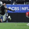 Raiders RB Ashton Jeanty, wearing number 2, runs with the football while a Kansas City Chiefs player dives after him.