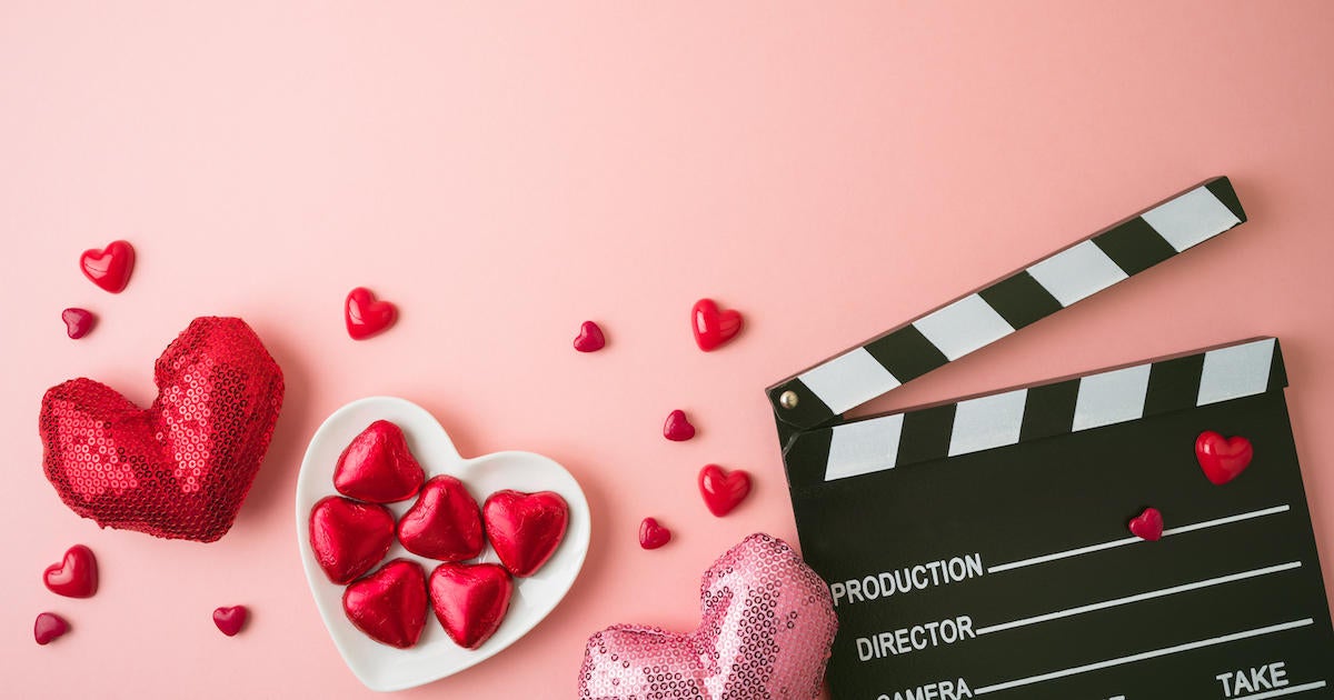 dating-tv-show-hearts-television-Happy Valentines day and romantic movie concept with  movie clapper board, heart shapes and chocolates on pink backgr