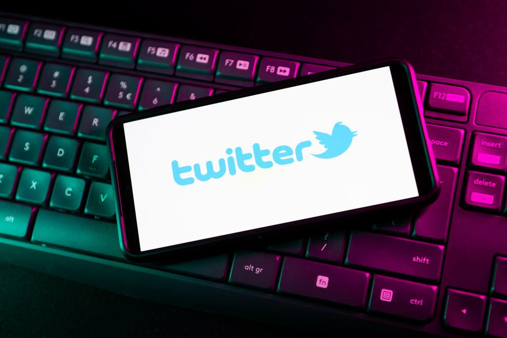 In this photo illustration a Twitter logo seen displayed on