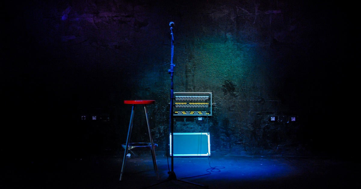 mic-and-stool-in-an-dark-empty-stage-with-an-open-connections-box