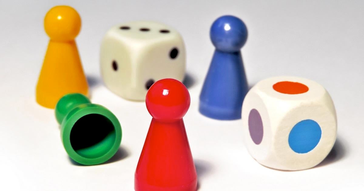 Close-Up Of Colorful Ludo Tokens With Dices On White Background