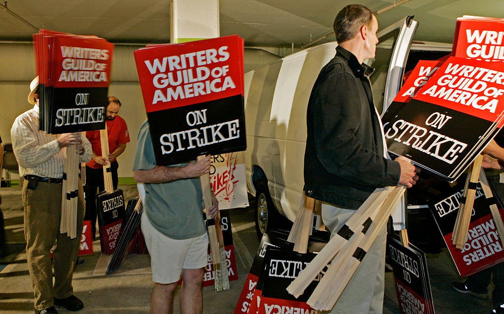 Writers Guild members load picket signs into vans inside the parking garage at the Writer's Guild A
