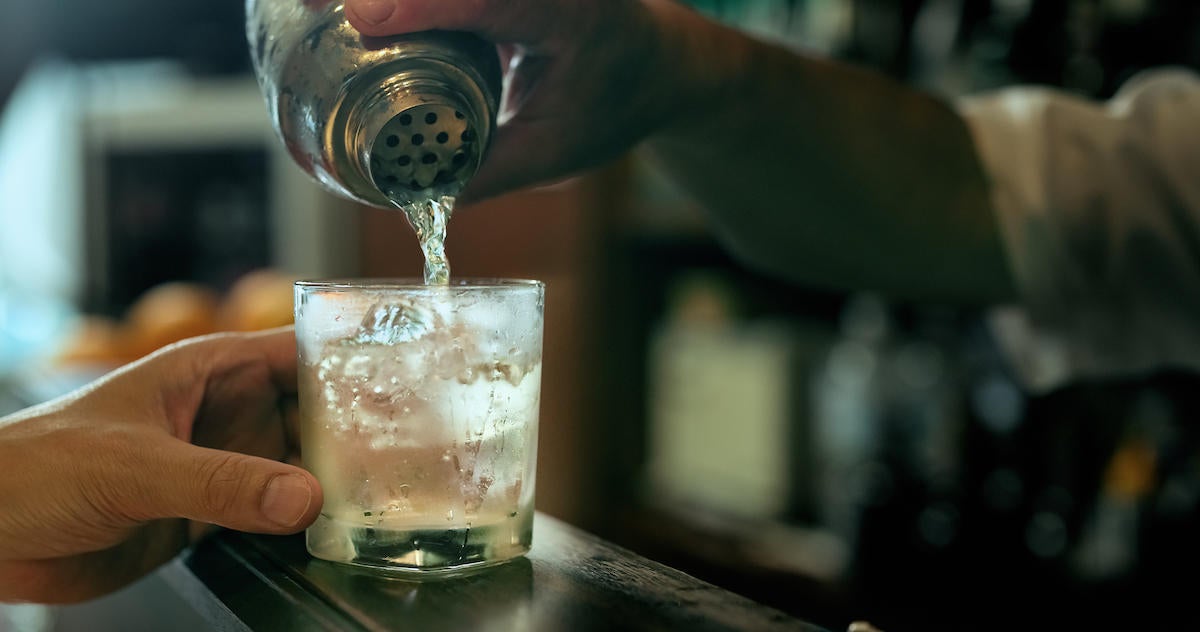 Close-up of bartender hand pouring cocktail