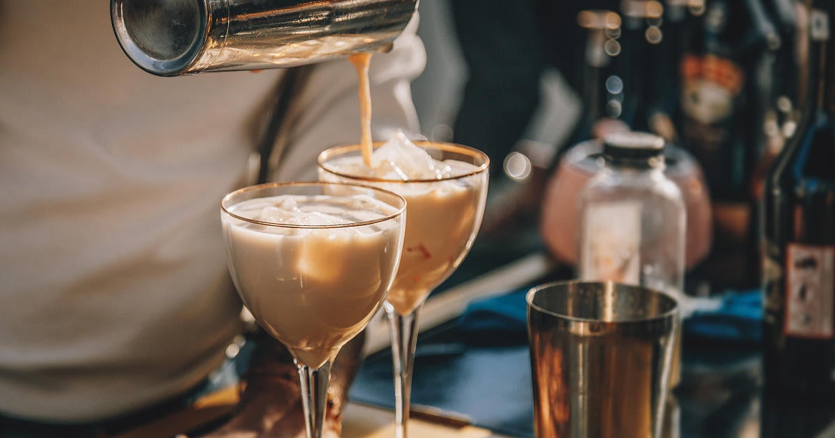 bartender-making-baileys-cocktail-with-ice-and-pouring-to-glass-from-bar-shaker