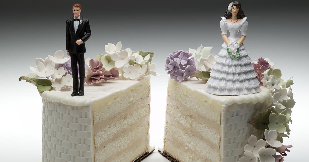 bride-and-groom-figurines-standing-on-two-separated-slices-of-wedding-cake