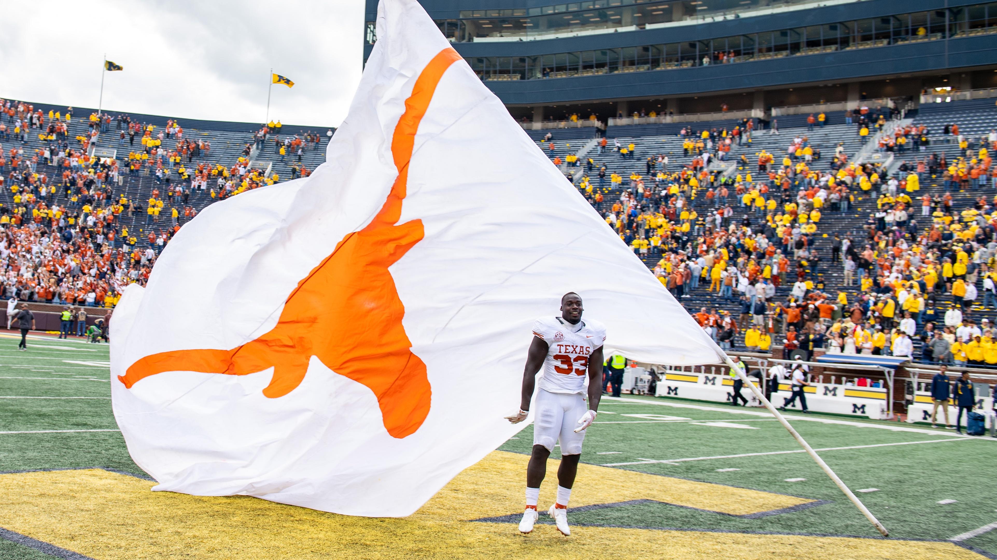 WATCH: Texas LB tries to plant Longhorns flag on midfield logo at Michigan Stadium after win over Wolverines