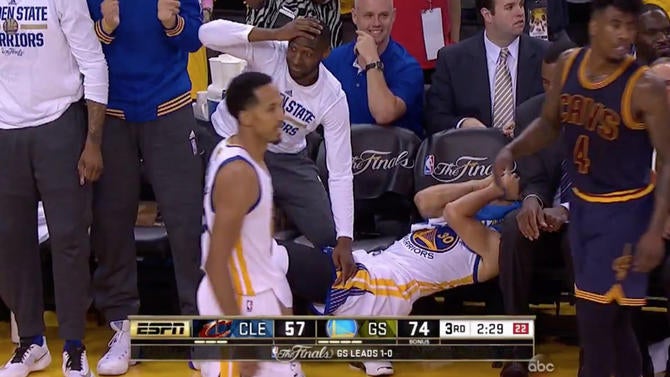 Stephen Curry covers his eyes on the bench