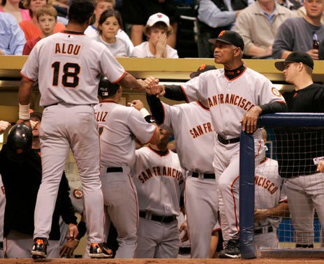 San Francisco Giants manager Felipe Alou, right, welcomes Pedro Feliz, No. 7, and Moises Aloug, No 18, into the dugout after Feliz hit a two-run against the Milwaukee Brewers in the second inning at Miller Park in Milwaukee, Wisconsin on Wednesday, May 3,