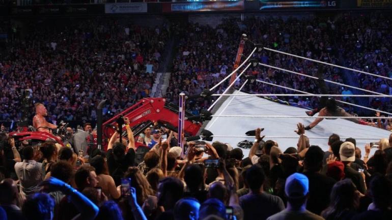 Tonton saat Brock Lesnar menggunakan traktor untuk mengangkat ring, membuang Roman Reigns selama WWE SummerSlam