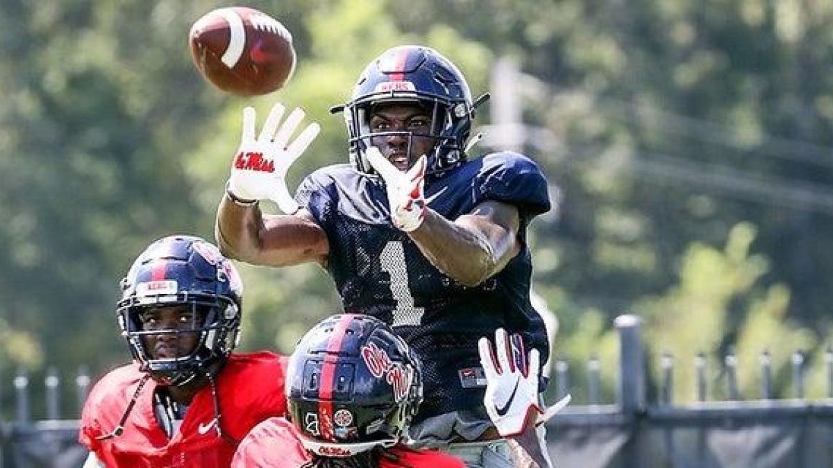 Ole Miss wide receivers warming up with Coach Derrick Nix