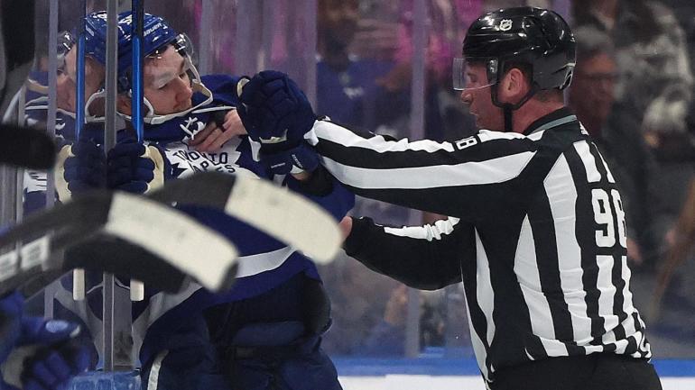 PERHATIKAN: Linesman mendorong Michael Bunting dari Maple Leafs keluar dari es setelah scrum