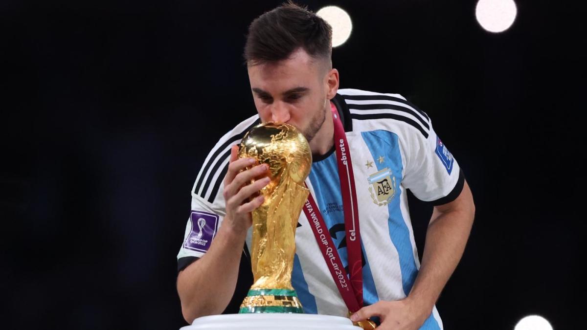 El defensa argentino Nicolás Tagliafico besa el trofeo del Mundial mientras celebraba su boda