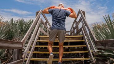Cheerful sportswoman with bottle and towel