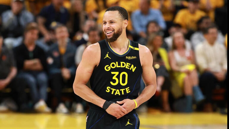 Stephen Curry arremessando pela linha de três pontos em jogo da NBA.