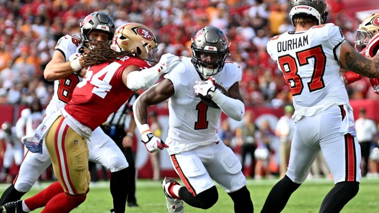 Fred Warner dos 49ers sendo atendido após lesão no pé contra os Buccaneers