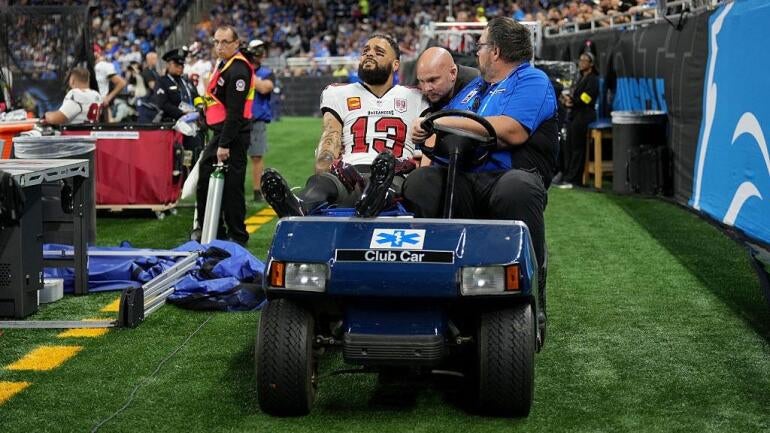 Mike Evans sendo retirado de campo em maca durante jogo dos Buccaneers contra os Lions.