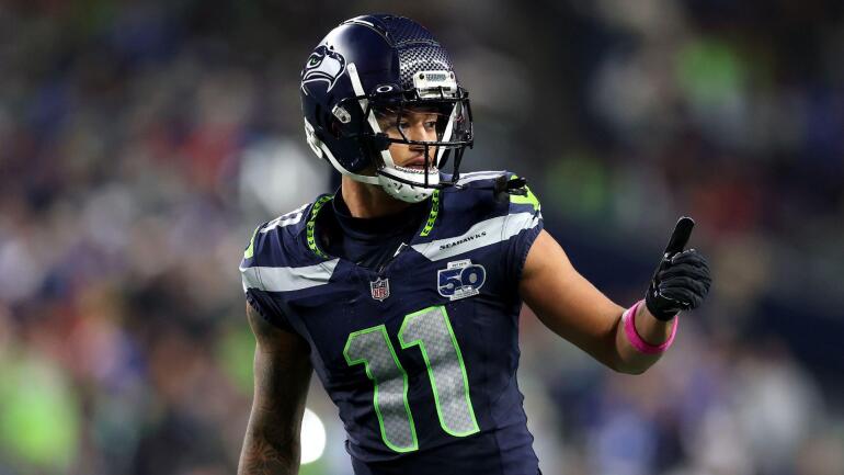 Jaxon Smith-Njigba cercado por jogadores do Houston Texans após interceptação.