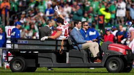 Cam Skattebo sendo retirado de campo de maca.