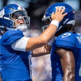 New York Giants quarterback Jaxson Dart (6) celebrates with New York Giants wide receiver Malachi Fields (0) after scoring a