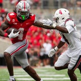 Ohio State Buckeyes wide receiver Jeremiah Smith (4) runs past Ball State Cardinals defensive back Willizhuan Yates (4) during