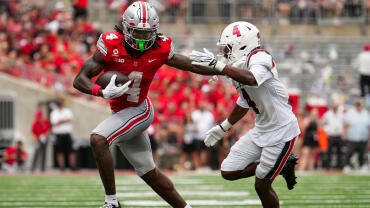 Ohio State Buckeyes wide receiver Jeremiah Smith (4) runs past Ball State Cardinals defensive back Willizhuan Yates (4) during