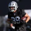 Raiders TE Brock Bowers runs with a football during preseason training camp.