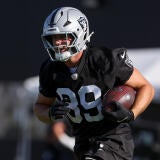 Raiders TE Brock Bowers runs with a football during preseason training camp.