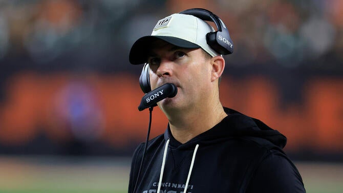 Bengals coach Zac Taylor wears a headset and looks up during a preseason game.
