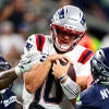 Patriots QB Drake Maye gets sacked by two Seattle defenders.