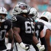 Raiders' Adam Butler wears a number 69 jersey and celebrates after a tackle.