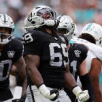 Raiders' Adam Butler wears a number 69 jersey and celebrates after a tackle.