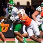 Oregon quarterback Dante Moore is sacked by Oklahoma State defensive end Keviyan Huddleston as the Oregon Ducks face the