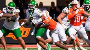 Oregon quarterback Dante Moore is sacked by Oklahoma State defensive end Keviyan Huddleston as the Oregon Ducks face the