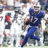 Number 17 Josh Allen runs with the football in one hand on a drive against the Houston Texans.