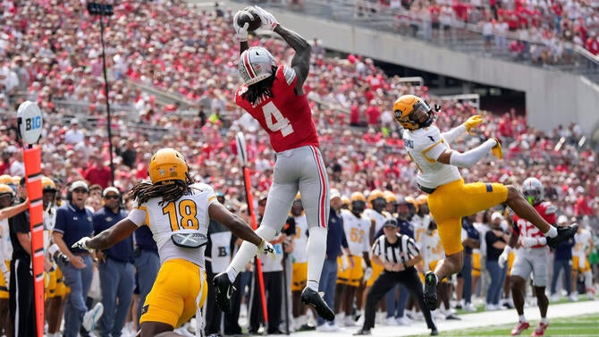 Ohio State Buckeyes wide receiver Jeremiah Smith (4) makes a catch against Kent State Golden Flashes defensive back Norey