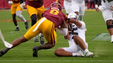 Oregon quarterback Dante Moore is hit after sliding by USC linebacker Desman Stephens II as the Oregon Ducks face the USC