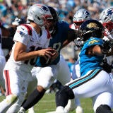 Jacksonville Jaguars defensive end Bryan Thomas Jr. (57), right, combines to tackle New England Patriots quarterback Drake Maye