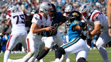 Jacksonville Jaguars defensive end Bryan Thomas Jr. (57), right, combines to tackle New England Patriots quarterback Drake Maye