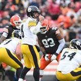 Pittsburgh QB Aaron Rodgers stands in a white jersey and makes a call at the line of scrimmage against the Cleveland Browns.