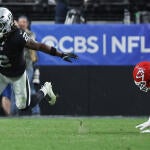 Raiders RB Ashton Jeanty, wearing number 2, runs with the football while a Kansas City Chiefs player dives after him.