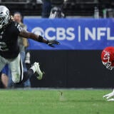 Raiders RB Ashton Jeanty, wearing number 2, runs with the football while a Kansas City Chiefs player dives after him.