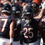 A group of five Chicago Bears players in blue jerseys celebrate a touchdown.