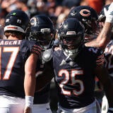 A group of five Chicago Bears players in blue jerseys celebrate a touchdown.