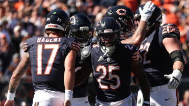 A group of five Chicago Bears players in blue jerseys celebrate a touchdown.