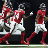 A group of five Chicago Bears players in blue jerseys celebrate a touchdown.
