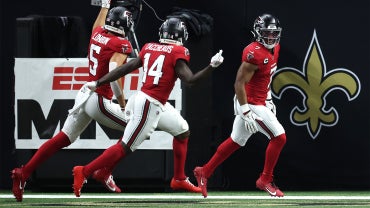 A group of five Chicago Bears players in blue jerseys celebrate a touchdown.